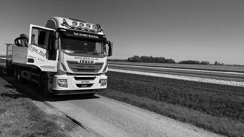 White GT Trax truck on a road with grass verge on either side